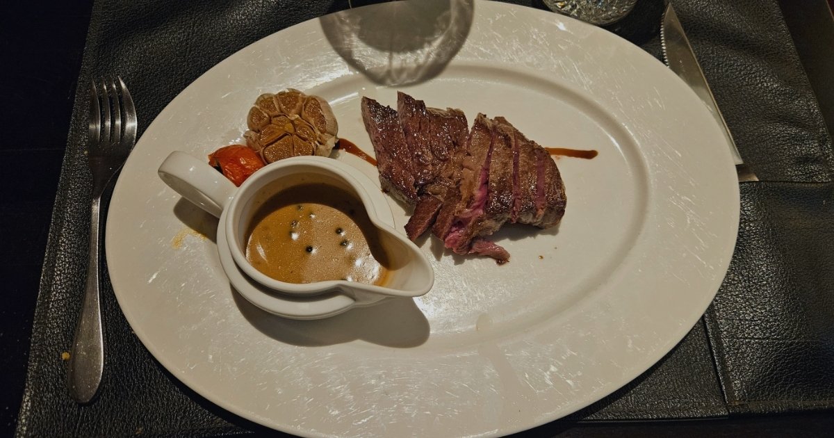 Image of Dinner plate with Wagyu beef, sauce and roasted garlic